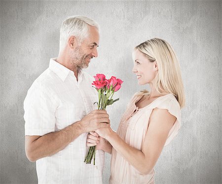 simsearch:400-07957355,k - Affectionate man offering his partner roses against weathered surface Stock Photo - Budget Royalty-Free & Subscription, Code: 400-07957387