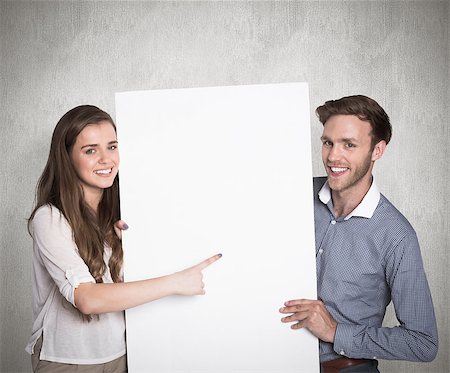 simsearch:400-07957355,k - Happy young couple with blank board against weathered surface Stock Photo - Budget Royalty-Free & Subscription, Code: 400-07957381