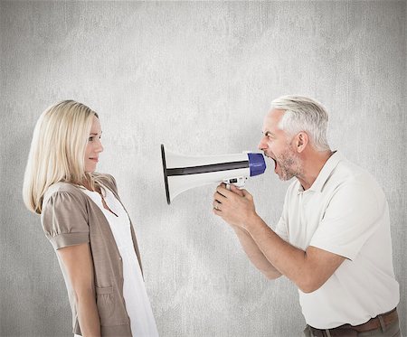 simsearch:400-07957420,k - Angry man shouting at girlfriend through megaphone against weathered surface Photographie de stock - Aubaine LD & Abonnement, Code: 400-07957406