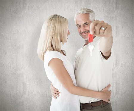 simsearch:400-07957355,k - Happy couple showing their new house key against weathered surface Stock Photo - Budget Royalty-Free & Subscription, Code: 400-07957409