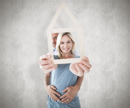 simsearch:400-07957420,k - Happy couple holding house outline  against weathered surface Photographie de stock - Aubaine LD & Abonnement, Code: 400-07957401