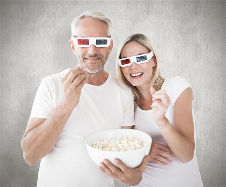 simsearch:400-07957420,k - Happy couple wearing 3d glasses eating popcorn against weathered surface Photographie de stock - Aubaine LD & Abonnement, Code: 400-07957411
