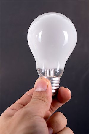 simsearch:400-04265413,k - Holding white bulb with black color background Stock Photo - Budget Royalty-Free & Subscription, Code: 400-07951988