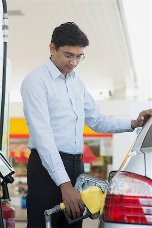 Pumping gas. Asian Indian man pumping gasoline fuel in car at gas station. Stock Photo - Budget Royalty-Free & Subscription, Code: 400-07978327