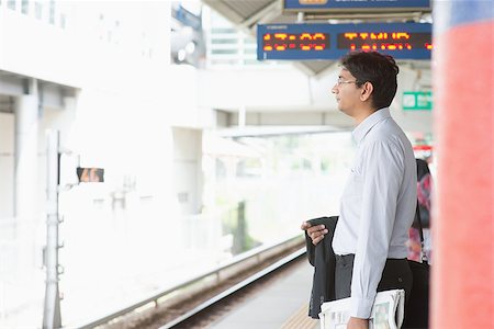 Candid Asian Indian businessman waiting at public train station. Stock Photo - Budget Royalty-Free & Subscription, Code: 400-07978351