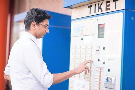 Asian Indian businessman buying transport ticket at vending machine. Stock Photo - Budget Royalty-Free & Subscription, Code: 400-07978366