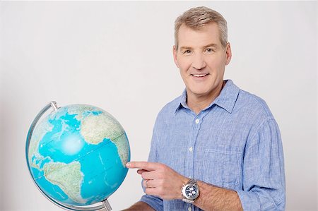 Senior man holding globe and pointing Stock Photo - Budget Royalty-Free & Subscription, Code: 400-07984815