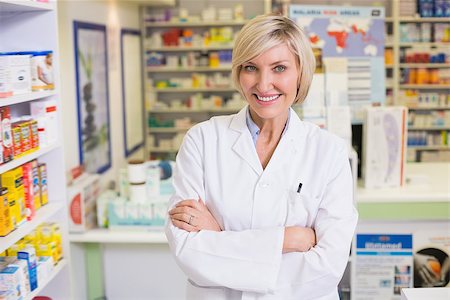smiling pharmacist in lab coat looking at camera in the pharmacy Stock Photo - Budget Royalty-Free & Subscription, Code: 400-07990593