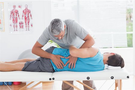 simsearch:400-05318677,k - Doctor examining man back in medical office Stock Photo - Budget Royalty-Free & Subscription, Code: 400-08018624