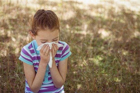 Cute little girl blowing her nose in park on a sunny day Stock Photo - Budget Royalty-Free & Subscription, Code: 400-08019073