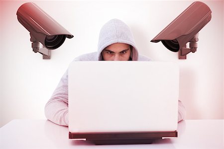 Serious burglar hacking into laptop against cctv camera Stock Photo - Budget Royalty-Free & Subscription, Code: 400-08019183