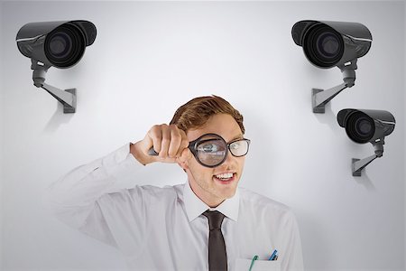 Geeky businessman looking through magnifying glass against cctv camera Stock Photo - Budget Royalty-Free & Subscription, Code: 400-08019217