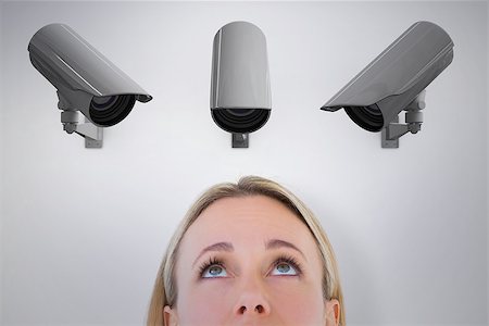 Close up of blonde woman looking up against cctv camera Stock Photo - Budget Royalty-Free & Subscription, Code: 400-08019219