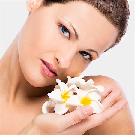 Close up portrait of a beautiful blonde woman holding plumeria flowers close to the face Stock Photo - Budget Royalty-Free & Subscription, Code: 400-08075562