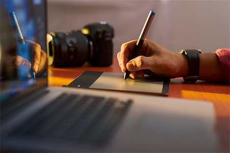 diego_cervo (artist) - Photographer drawing and retouching image on laptop computer, using a digital tablet and stylus pen. Closeup of man's hand with dslr camera in background. Copy space in foreground Stock Photo - Budget Royalty-Free & Subscription, Code: 400-08077788