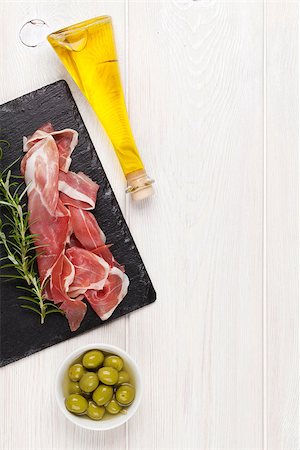 simsearch:400-06207145,k - Prosciutto with rosemary, olives and olive oil on wooden table. Top view with copy space Stock Photo - Budget Royalty-Free & Subscription, Code: 400-08112914
