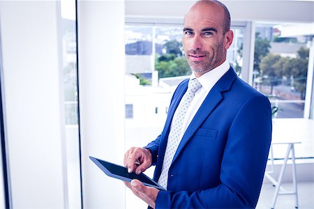 simsearch:400-04283915,k - Businessman using his tablet pc in his office Stock Photo - Budget Royalty-Free & Subscription, Code: 400-08136279