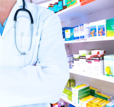 Doctor standing arms crossed  against close up of shelves of drugs Stock Photo - Budget Royalty-Free & Subscription, Code: 400-08137532