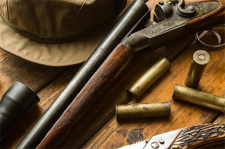 Hunting rifle, ammunition, a knife and a cap on the wooden table, close-up Stock Photo - Budget Royalty-Free & Subscription, Code: 400-08152733