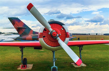 simsearch:400-08188604,k - Front view of the part of the fuselage of the old military single-engine plane with a propeller. The airplane parked on the green grass. Selective focus on propeller. Stock Photo - Budget Royalty-Free & Subscription, Code: 400-08188605