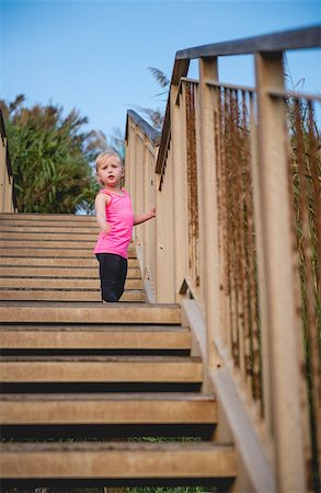 Half way to the top! This cute little girl looks back in pride, looking at how far she has already climbed up this big wooden staircase. Stock Photo - Budget Royalty-Free & Subscription, Code: 400-08198089