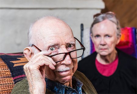 Concerned elderly couple sitting in livingroom scowling Stock Photo - Budget Royalty-Free & Subscription, Code: 400-08254986