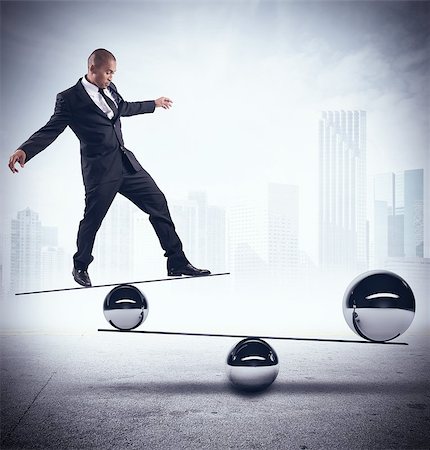 Businessman balancing on boards with iron balls Stock Photo - Budget Royalty-Free & Subscription, Code: 400-08257615