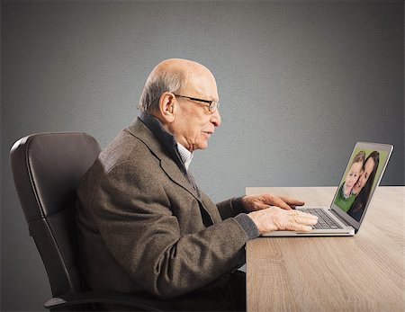 Grandpa talking with distant family with webcam Stock Photo - Budget Royalty-Free & Subscription, Code: 400-08253461