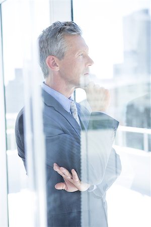 simsearch:400-04283915,k - Thinking businessman in the office looking through the window Stock Photo - Budget Royalty-Free & Subscription, Code: 400-08264470
