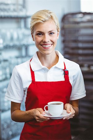 simsearch:400-07750853,k - Pretty barista holding a cup of coffee at the cafe Stock Photo - Budget Royalty-Free & Subscription, Code: 400-08265816