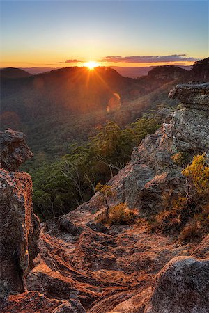 The last rays of sunshine stream over Wilsons Gully and the valley and highlight the foreground cliffs and rock ledges and foliage.  Sunset views from Sunset Rock, Mt Victoria in the Blue Mountains, Australia Stock Photo - Budget Royalty-Free & Subscription, Code: 400-08284113