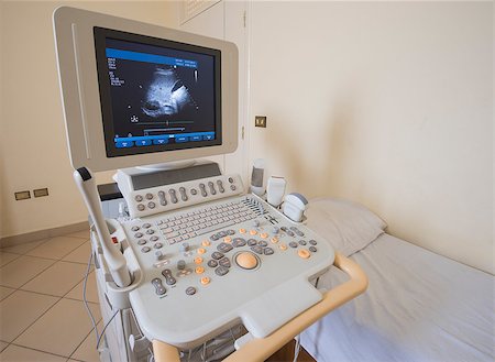 Examination bed with ultrasound scanner machine in medical center hospital Stock Photo - Budget Royalty-Free & Subscription, Code: 400-08284259