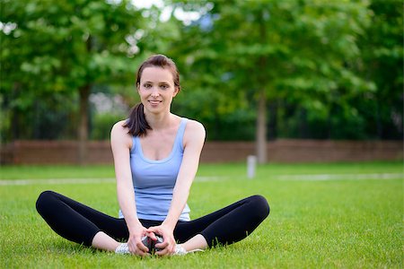 Beautiful Smiling Woman Doing Stretching Exercise on the Grass in the Park. Sport and Fitness Concept Stock Photo - Budget Royalty-Free & Subscription, Code: 400-08287654