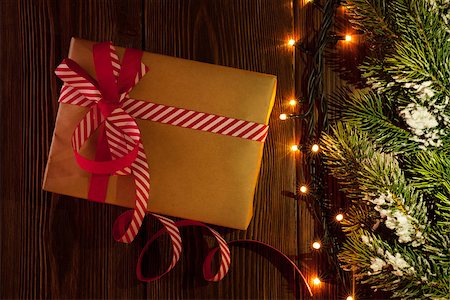 Christmas gift box, tree branch and lights on wooden background Stock Photo - Budget Royalty-Free & Subscription, Code: 400-08296830