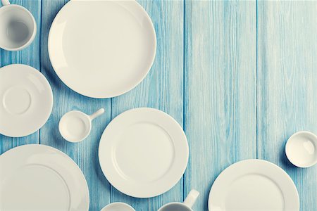 setting kitchen table - Empty plates and bowls on blue wooden background. Retro toned. Top view with copy space Stock Photo - Budget Royalty-Free & Subscription, Code: 400-08298807