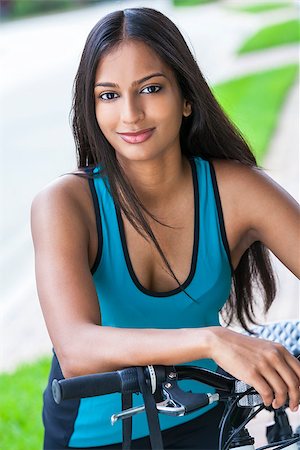 Outdoor fitness portrait of a beautiful Indian Asian young woman or girl outside in summer sunshine riding cycling her bicycle Stock Photo - Budget Royalty-Free & Subscription, Code: 400-08290430