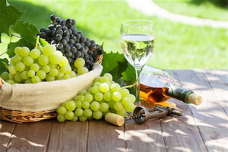 simsearch:846-05647552,k - White wine bottle and glass, red and white grape on garden table Stock Photo - Budget Royalty-Free & Subscription, Code: 400-08293342
