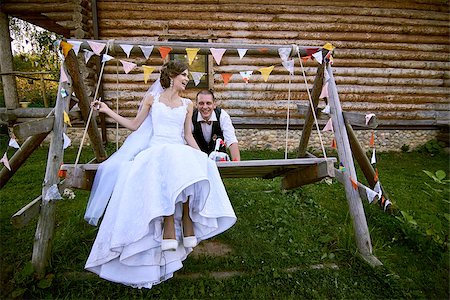 Newlyweds on swing on wood with wooden wall on the background.Villiage side. Stock Photo - Budget Royalty-Free & Subscription, Code: 400-08319195