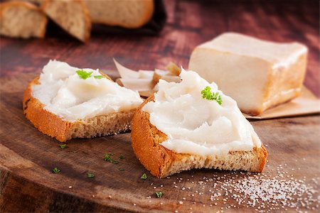 simsearch:400-04885499,k - Bread slice with lard on vintage wooden chopping board on wooden background. Traditional eating. Stock Photo - Budget Royalty-Free & Subscription, Code: 400-08344590