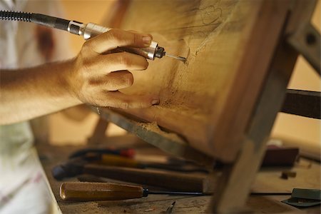 simsearch:400-07899762,k - Adult man at work as artist, chiselling a bas-relief in his atelier. He works with a drill to ceasel a wood painting. Stock Photo - Budget Royalty-Free & Subscription, Code: 400-08348831