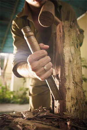 simsearch:400-07899762,k - Young man at work learning craftsman profession, working with hammer and chisel. The artist carves a raw block of wood to make a wooden statue Stock Photo - Budget Royalty-Free & Subscription, Code: 400-08378347