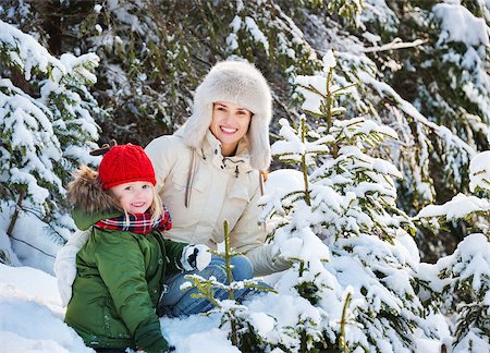 Winter outdoors can be fairytale-maker for children or even adults. Happy mother and child outdoors among snowy spruces Stock Photo - Budget Royalty-Free & Subscription, Code: 400-08379002