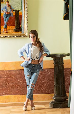 simsearch:400-04856416,k - indoor fashion portrait of young brunette female wearing torn jeans, heels and jacket. Posing in old palace with canvas backward Stock Photo - Budget Royalty-Free & Subscription, Code: 400-08371513