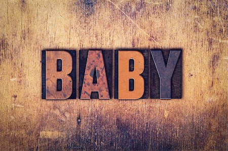 The word "Baby" written in dirty vintage letterpress type on a aged wooden background. Foto de stock - Super Valor sin royalties y Suscripción, Código: 400-08409451