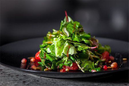 Delicious appetizer with herbs and pomegranate seeds on black plate close up Stock Photo - Budget Royalty-Free & Subscription, Code: 400-08402080