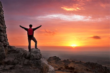 silhouette of man standing in a mountain top - Man on top of mountain with his arms raised to have reached the goal after a great effort admiring the sunrise Stock Photo - Budget Royalty-Free & Subscription, Code: 400-08426798