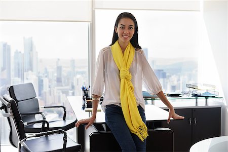 diego_cervo (artist) - Young multiethnic Chinese Hispanic female entrepreneur leaning on table in a modern office building, with sight of the city. She looks at camera and smiles happy Stock Photo - Budget Royalty-Free & Subscription, Code: 400-08432918