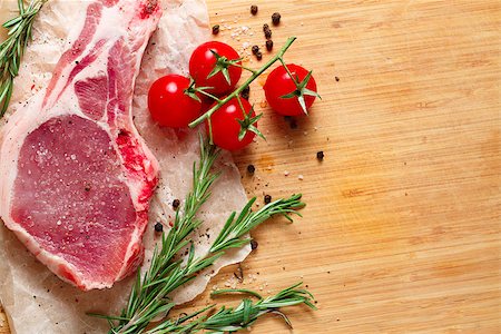 Pieces of crude meat with rosemary and tomatoes. Stock Photo - Budget Royalty-Free & Subscription, Code: 400-08433476