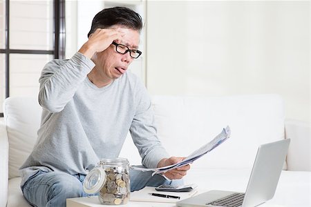 Stressed 50s mature Asian man paying bill at home. Saving, retirement, retirees financial planning concept. Stock Photo - Budget Royalty-Free & Subscription, Code: 400-08494621