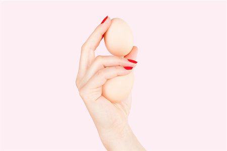 equality background hands - Female hand with red fingernails holding two eggs isolated on pink background. Feminism, emancipation, provocation and relationship problems. Stock Photo - Budget Royalty-Free & Subscription, Code: 400-08499207